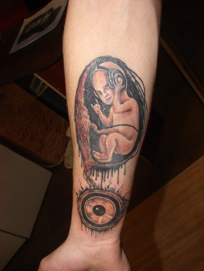 Tatuaje en el antebrazo, el embrión con auriculares, idea divertida
