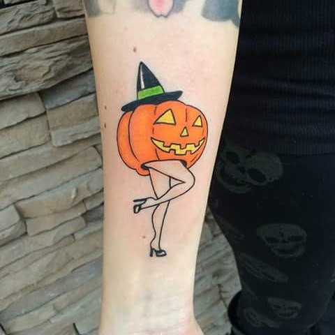 Unusual combined Halloween pumpkin with legs tattoo on arm