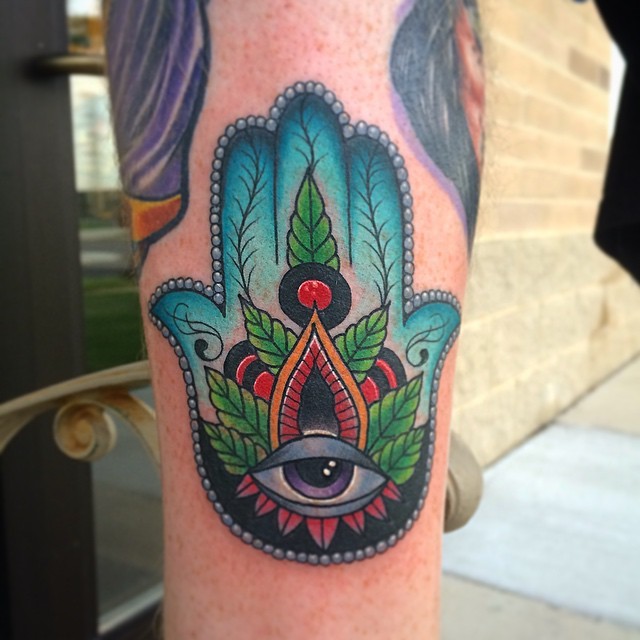 Tatuaje en la pierna,
jamsa decorada con hojas y ojo misterioso