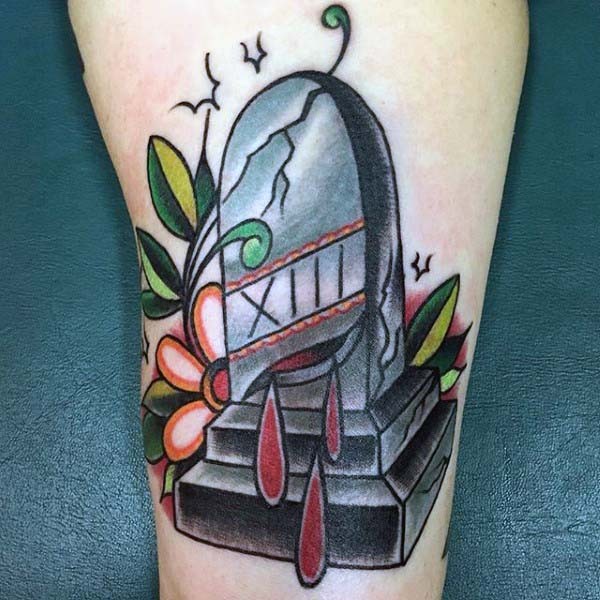 Unusual painted and colored bleeding tomb stone with flowers tattoo on leg