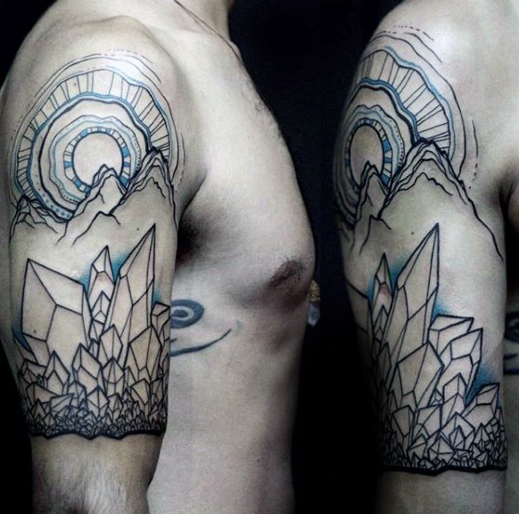 Usual black and white shoulder tattoo of mountains and crystals