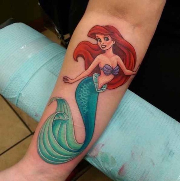 Usual colored little cartoon forearm tattoo of Ariel mermaid