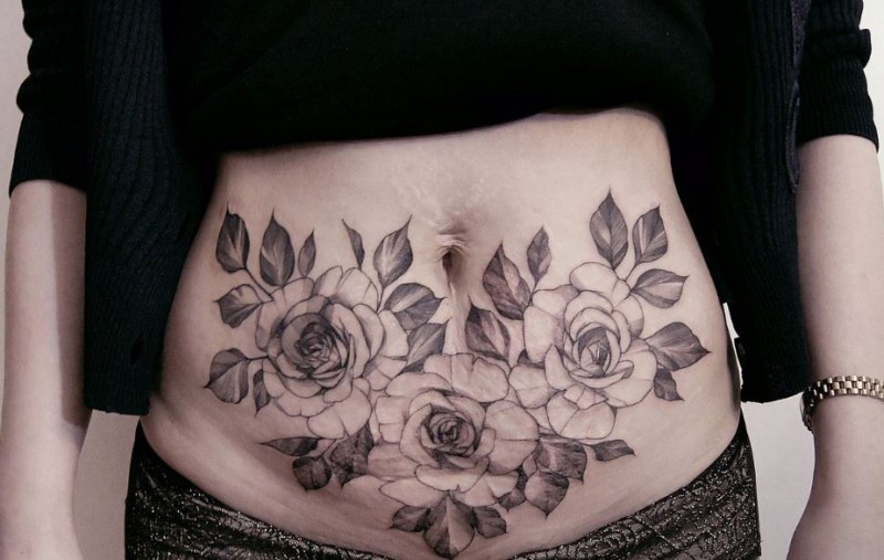 Usual designed by Zihwa tattoo of big roses on belly