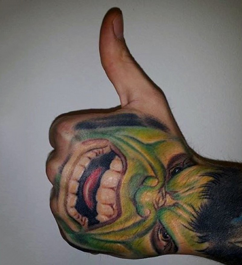 Usual designed colored Hulk face tattoo on hand