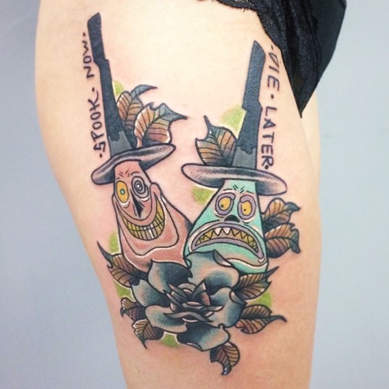 Usual old cartoon style funny monsters tattoo on thigh stylized with flowers and lettering