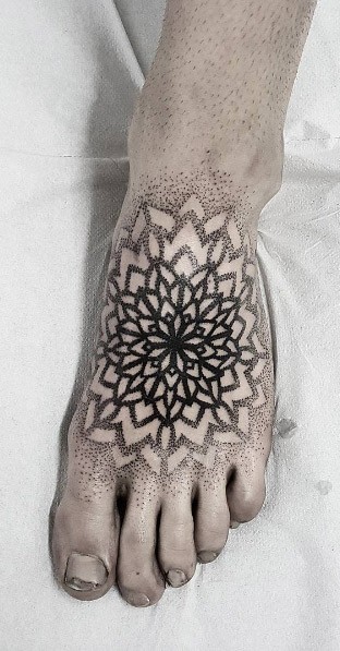 Usual simple looking dot style foot tattoo of big flowers