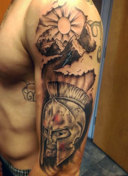 Tatuaje en el hombro,
cabeza de guerrero espartano  con montañas y sol, colores negro blanco
