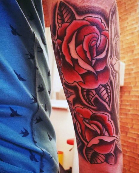 Usual style painted red colored big roses tattoo on arm