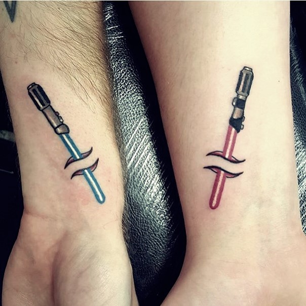 Üblicher Stil unter die Haut verschiedene farbige Tattoos mit Lichtschwerter an den Handgelenken