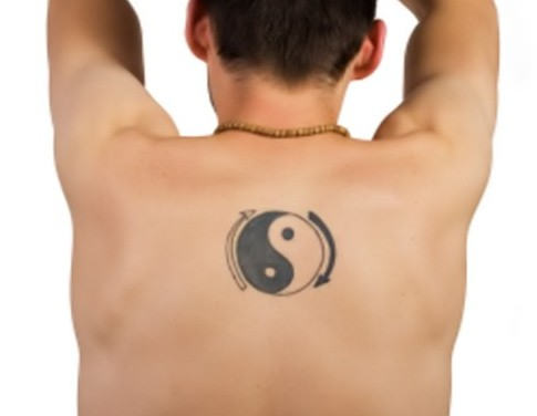 Tatuaje en la espalda, yin yang y flechas