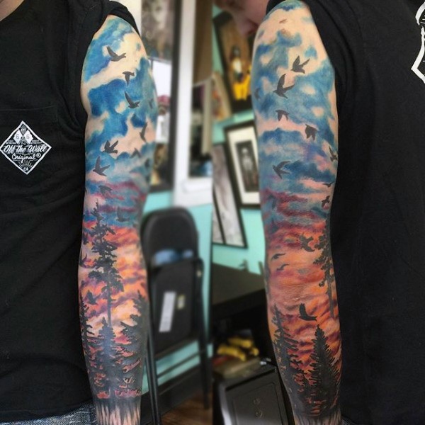 Tatuaje en el brazo, bosque oscuro con bandada de aves pequeñas
