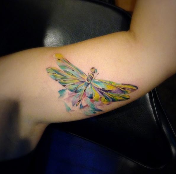 Tatuaje en el brazo,
 libélula maravillosa de varios colores