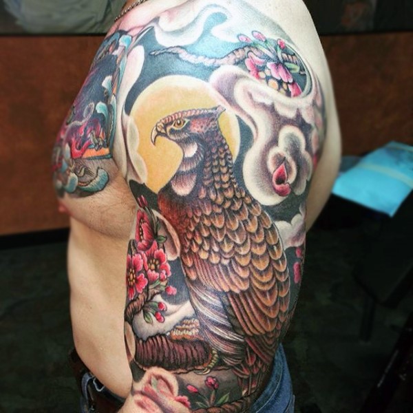 Very beautiful multicolored eagle with flowers tattoo on sleeve and chest