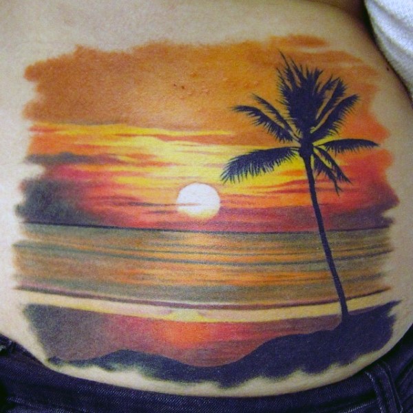 Very beautiful ocean sunset with lonely palm tree tattoo on waist
