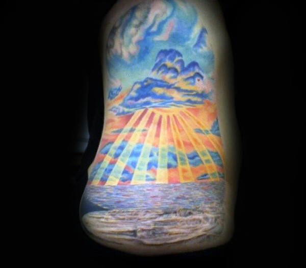 Tatuaje en el costado,  océano con rayos de sol y cielo lindo