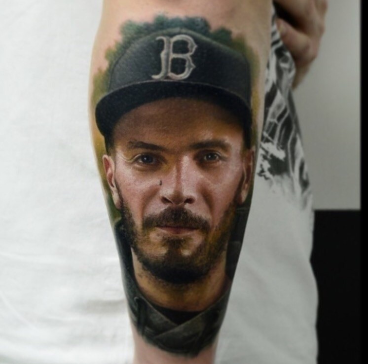 Very detailed arm tattoo of smiling man portrait