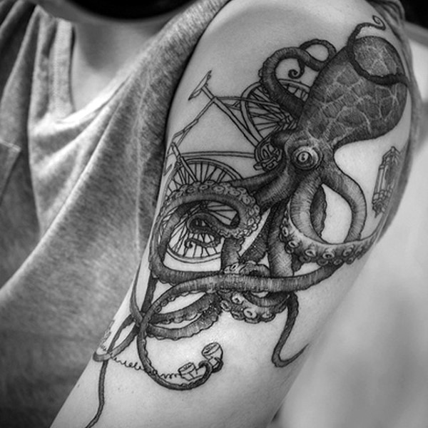Very detailed black and white octopus with bicycle tattoo on shoulder
