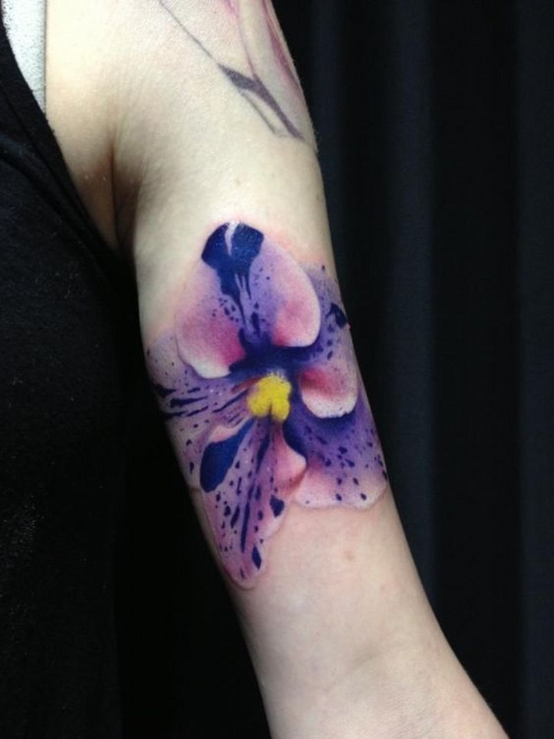 Very realistic detailed and colored flower tattoo on arm