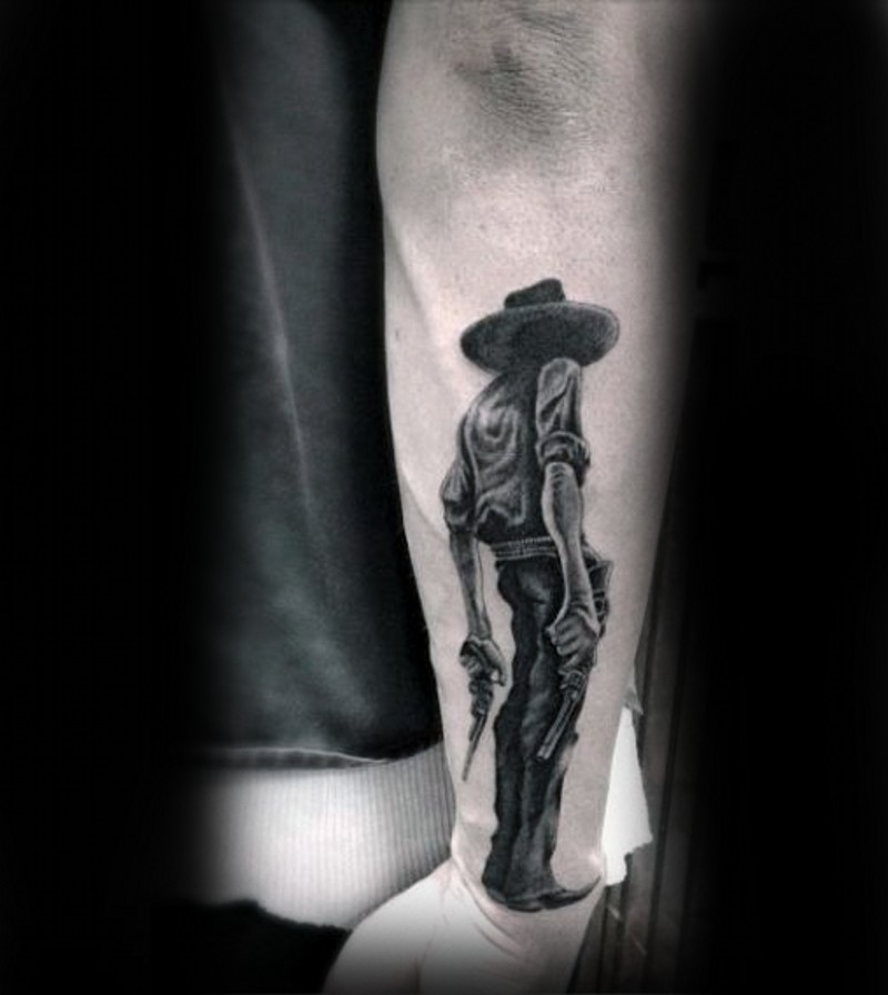 Very realistic looking 3D like black ink detailed cowboy with pistols tattoo on wrist