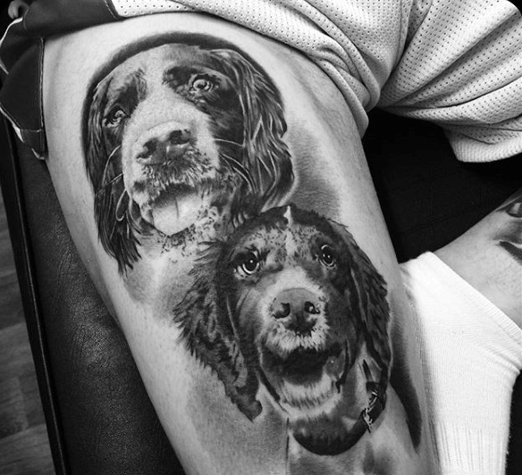 Very realistic looking black and white smiling dogs portrait tattoo on thigh