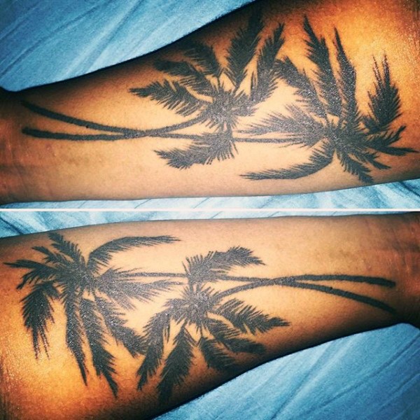 Sehr realistisch aussehende schwarze Palmen Tattoo am Arm