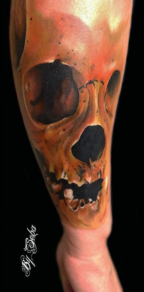 Very realistic looking colored forearm tattoo of massive skull