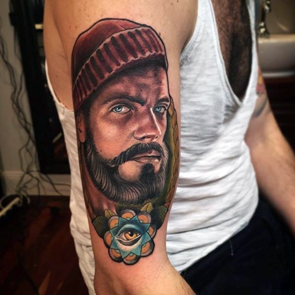 Tatuaje en el brazo, retrato de hombre hermoso con flor pequeña con ojo