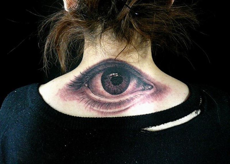Very realistic looking detailed black and white eye tattoo on upper back