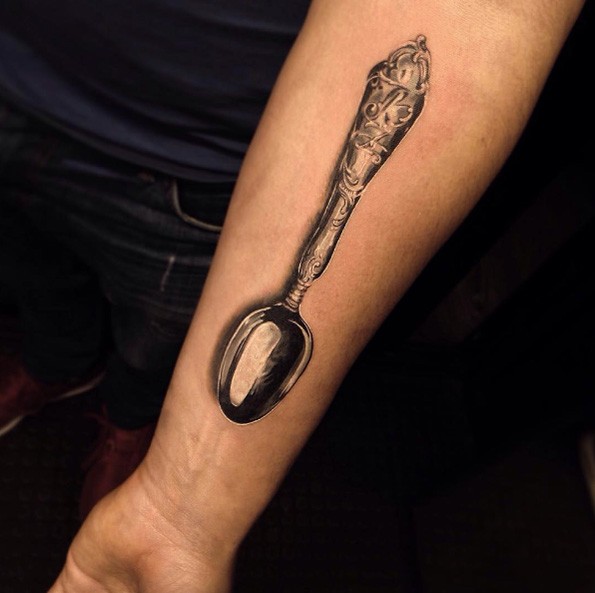 Very realistic looking detailed forearm tattoo of antic spoon