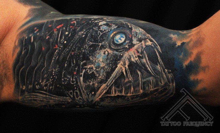 Very realistic looking great detailed creepy alien like fish tattoo on arm