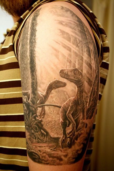 Tatuaje de dinosaurios en la selva en el brazo