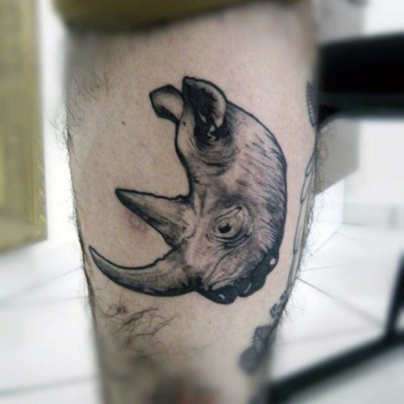Vintage photo style tiny black ink rhino head tattoo on leg muscle