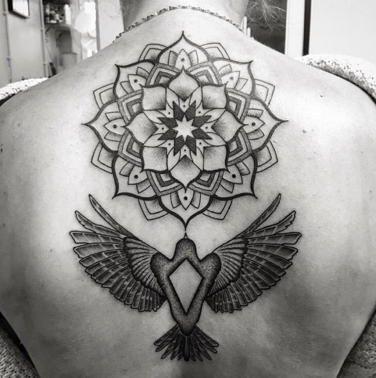 Vintage style black and white bird tattoo on back combined with ornamental flower