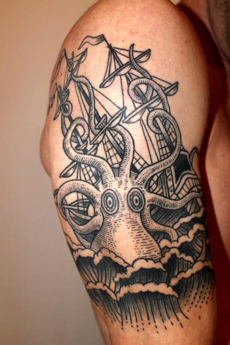 Vintage style black ink big octopus with sailing ship tattoo on shoulder