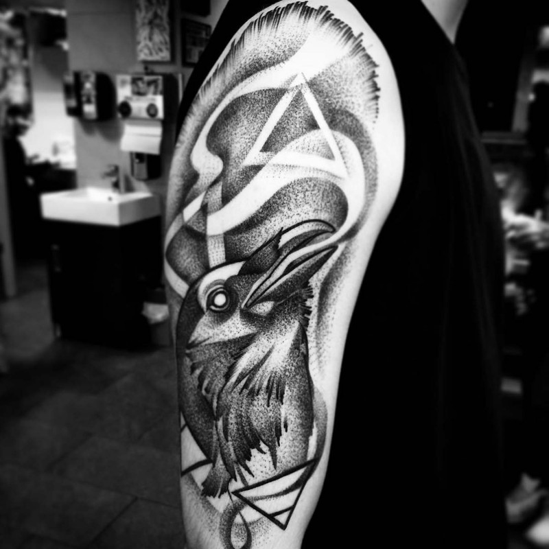 Vintage style black ink crow tattoo on half sleeve stylized with mystical triangles