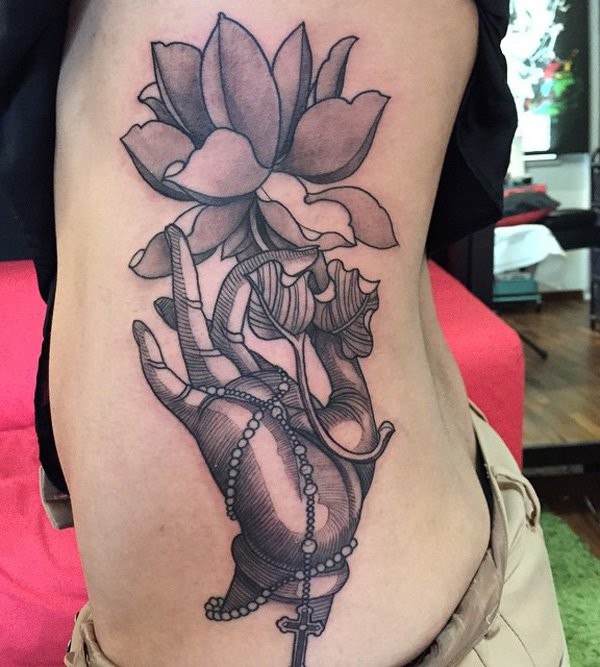 Vintage style black ink large hand with cross tattoo on side combined with beautiful flower