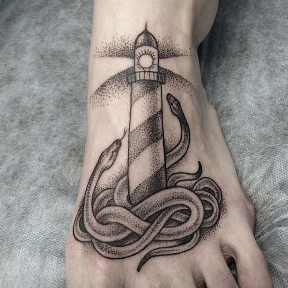 Vintage style black ink lighthouse tattoo on foot with snakes