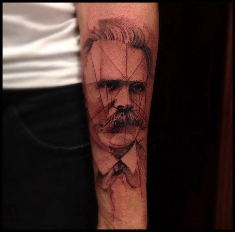 Vintage style black ink man with mustache head tattoo on forearm