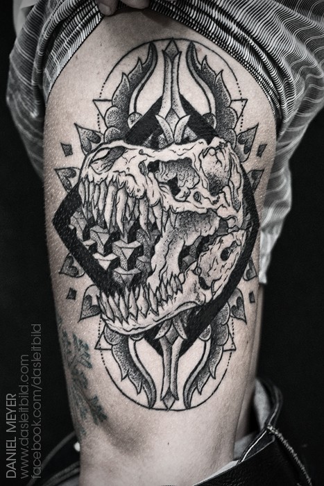 Vintage style black ink mystical dinosaur skull tattoo on thigh with black geometric figure