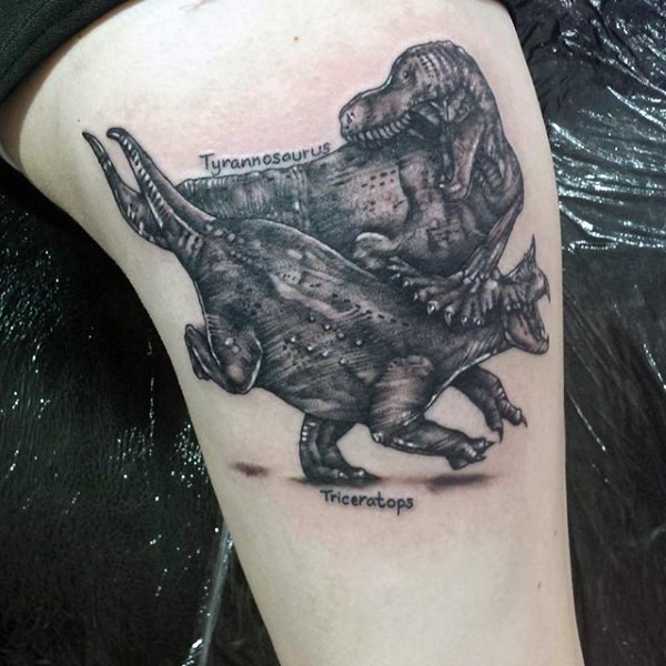 Vintage style black ink thigh tattoo of dinosaur fight and lettering