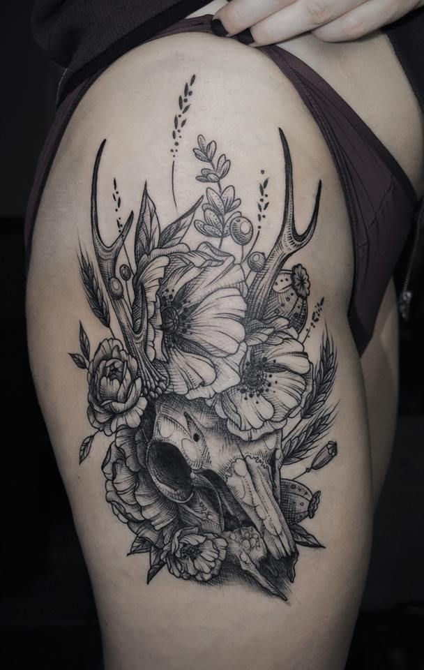 Vintage style black ink thigh tattoo of deers skull with various flowers