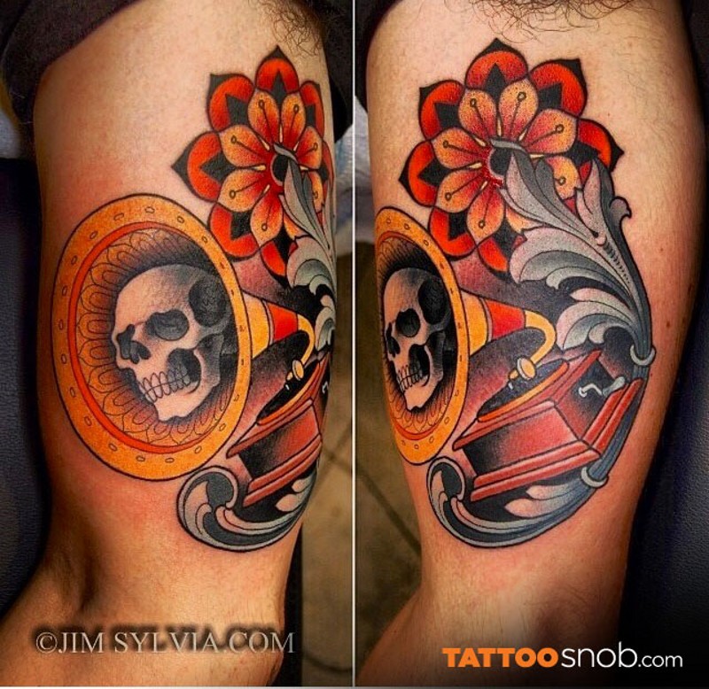 Vintage style multicolored gramophone tattoo on biceps stylized with ornamental flower and skull