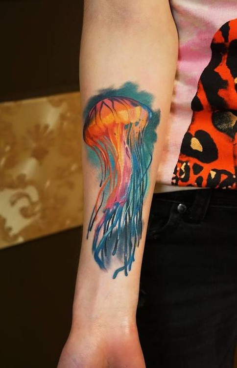 Vivid colors jellyfish in ocean forearm tattoo