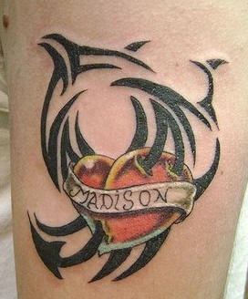 el tatuaje de un corazon rojo con un nombre con traceria tribal alrededor