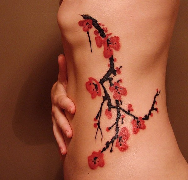 Tatuaggio carino sul fianco il ramo della sakura fiorito
