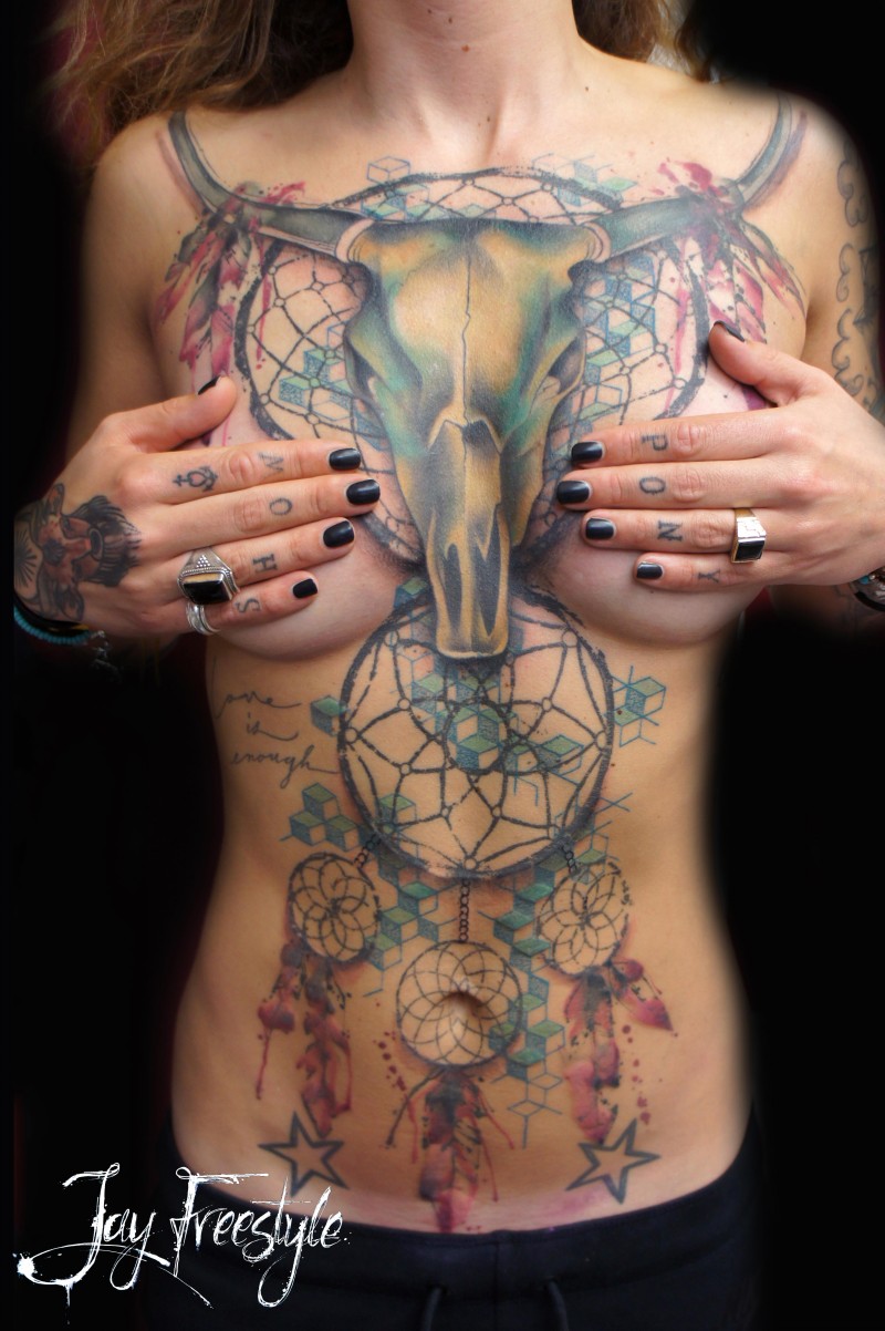 Tatuaje en el pecho y estómago, cráneo de toro y atrapasueños multicolores