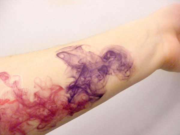 Watercolor like multicolored abstract tattoo on arm