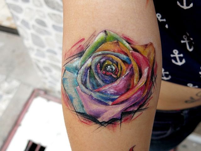 acquerello multicolore piccola rosa tatuaggio su braccio