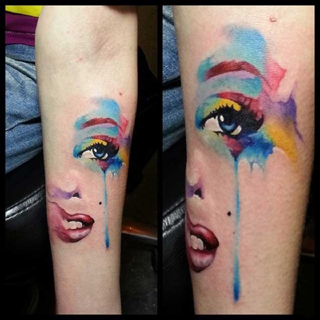 Watercolor like painted and colored tattoo on woman face parts