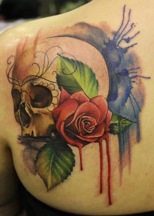 Watercolor skull and red rose tattoo on shoulder blade